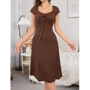Detail of dark brown lace nightdress featuring pleated texture and a silk ribbon bow