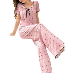 Pink two-piece women's pajama set with black bow prints and ruffled trim details
