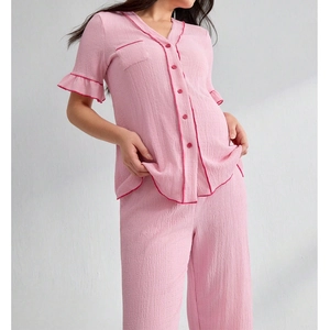 Detail of pink V-neck maternity loungewear featuring ruffled cuffs and textured fabric