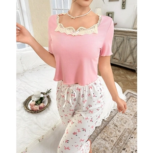 Close-up of pink rib-knit top with lace trim and floral print pajama bottoms on a model