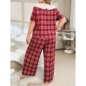 Red plaid short sleeve pajama set with white lace collar, back view on a cozy bed