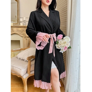 Robe de chambre plissée noire avec volants roses et ceinture dans un intérieur