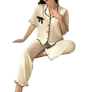 Women's pajama set in cream with black trim, short sleeve top and trousers with bows
