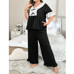 Détail du pyjama grande taille avec col en dentelle, nœud et ourlet à volants sur tissu noir