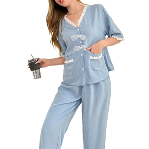Short-sleeve light blue pajamas set with white ruffles and bow details on white background