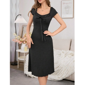 Detail of V-neck lace trim and black ribbon bow on a slim-fit ribbed summer nightdress