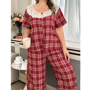 Detail of red plaid pajama set with large white lace collar and button-down short sleeves