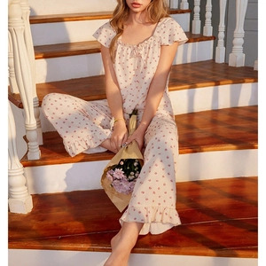 Women's floral pajama set with ruffled edges shown in a cozy indoor setting