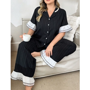 Detail of loose-fit black pajama set with white ruffles and textured stripe fabric