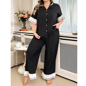 Women's black two-piece pajama set with white ruffle trim and vertical stripe texture