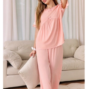 Ensemble de pyjama rose avec col rond et dentelle porté par un mannequin