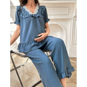 Détail du col en V avec dentelle et volants sur l'ensemble de pyjama maternité bleu