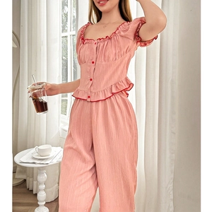 Detail of square neck summer pajama set in light pink with red ruffle trim and button accents