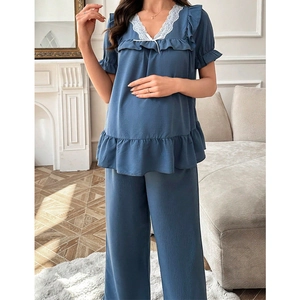 Détail de la dentelle col en V et ourlet à volants sur pyjama de maternité bleu marine