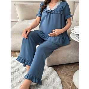 Détail du pyjama de maternité bleu-gris avec col en V en dentelle blanche et bord à volants