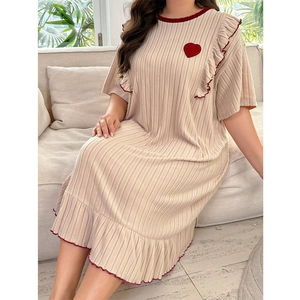 Detail view of beige ribbed sleepwear with red heart patch and ruffled edge trim