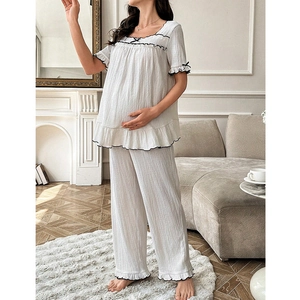 Loose maternity pajama set with short sleeves, black ruffled trim, and bow details