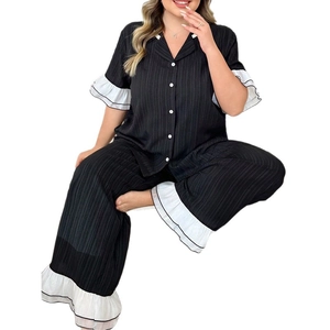 Women's black pleated pajama set with short sleeves and white ruffled trim details