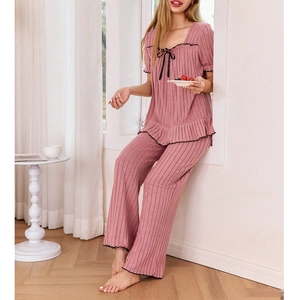 Detail of square neck pink ribbed pajama set with black bow and ruffled sleeve edges