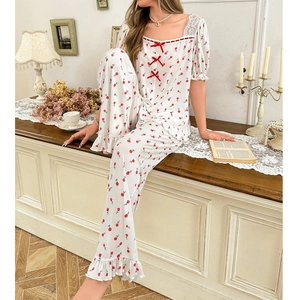 Floral square neck pajama set with lace trim and red bows in a vintage setting