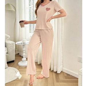 Détail du pyjama rose côtelé avec écusson cœur et nœud sur le haut à manches courtes
