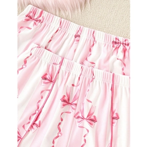 Détail du pantalon de pyjama à rayures roses avec nœuds doux et texture en maille côtelée