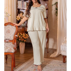 Detail of ruffled short-sleeved pajama top with black wave stitching and bow accent