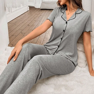 Détail du haut de pyjama gris à manches courtes avec liserés noirs et boutons élégants