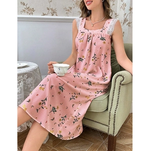 Detailed shot of pink floral square neck dress with white lace trim on a velvet chair