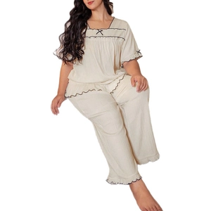 Women's cream-colored short sleeve pajama set with black wavy edges and bows
