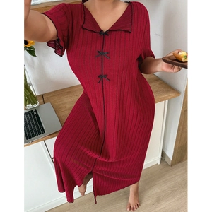 Détail de la chemise de nuit rouge foncé en tricot avec nœuds noirs et tissu texturé