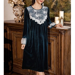 Close-up of elegant dark green velvet sleepwear with white floral lace cuffs and details
