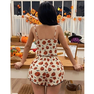Women Halloween pajama set with pumpkin bat print and ruffled shorts in festive kitchen