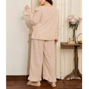 Peach Swiss dot lounge set for women featuring ruffled hems and wide-leg trousers
