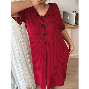 Détail d'une chemise de nuit côtelée rouge foncé avec col en V et trois nœuds noirs