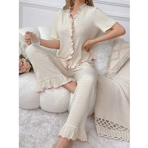 Close-up of women's short sleeve pajama top with pink ruffle trim and button cardigan