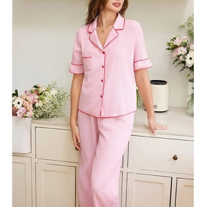 Detail of pink pajama set featuring ruffled sleeves and contrast red piping accents