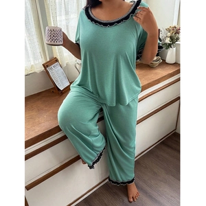 Detail of light green pajamas with elegant black and white wave lace trim on hems