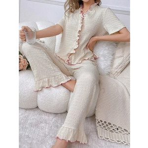 Women's two-piece beige pajama set with pink ruffle trim and short sleeve button-down top