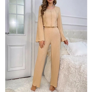 Détail de la texture côtelée et de l'ourlet ondulé sur le haut de pyjama beige doux