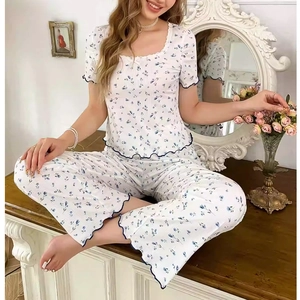 Dettaglio del pigiama floreale da donna con scollo in pizzo e bordi con volant blu