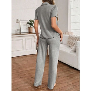 Detail view of grey pajama set showing ruffled hem and contrast piping from the back