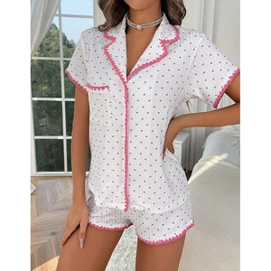 Detail of pink wavy trim and red heart print on white short-sleeved pajama set