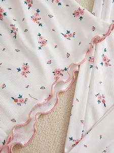 Close-up of pink floral ribbed fabric with sweet ruffled edges on pajama top detail