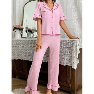 Pink two-piece pajama set with short-sleeve cardigan and ruffled pants in seersucker fabric