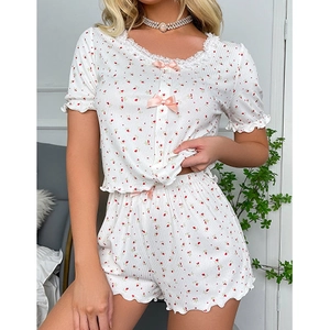 Pyjama floral doux avec manches courtes, bords à volants et détails de nœud rose