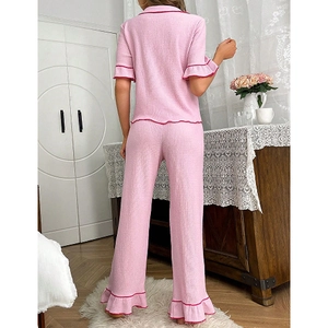 Women's pink pajama set featuring short sleeve lapel top and long pants with wavy red trim