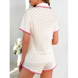Detail of pink crochet wavy trim on white heart print pajama shorts and sleeve hems