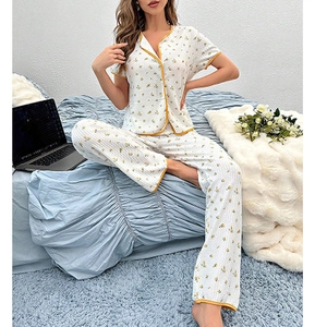 Women's floral pajama set featuring short-sleeve button-up top and long pants in cream