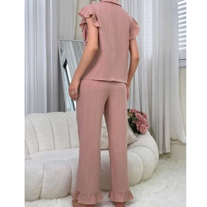 Detail of pink pajama set featuring ruffled sleeve hems and vertical pleated texture
